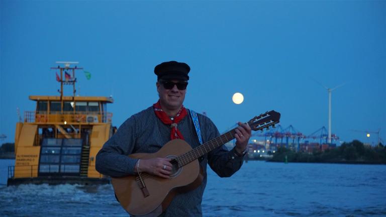 Nachts im Hafen: Der Seemannsköpper an der Elbe mit Hafenfähre und Mond über den Kränen