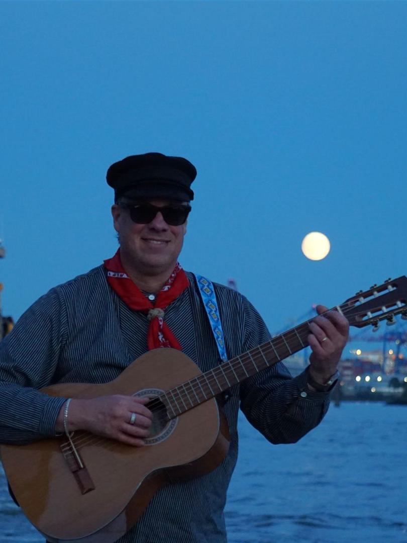 Nachts im Hafen: Der Seemannsköpper an der Elbe mit Hafenfähre und Mond über den Kränen